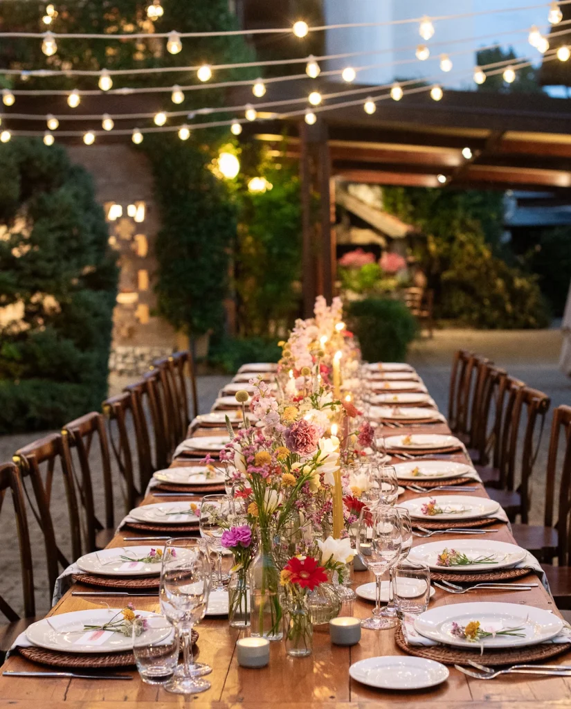 Allestimento cortile del ristorante Diodona per una cena con tavolo imperiale e fiori